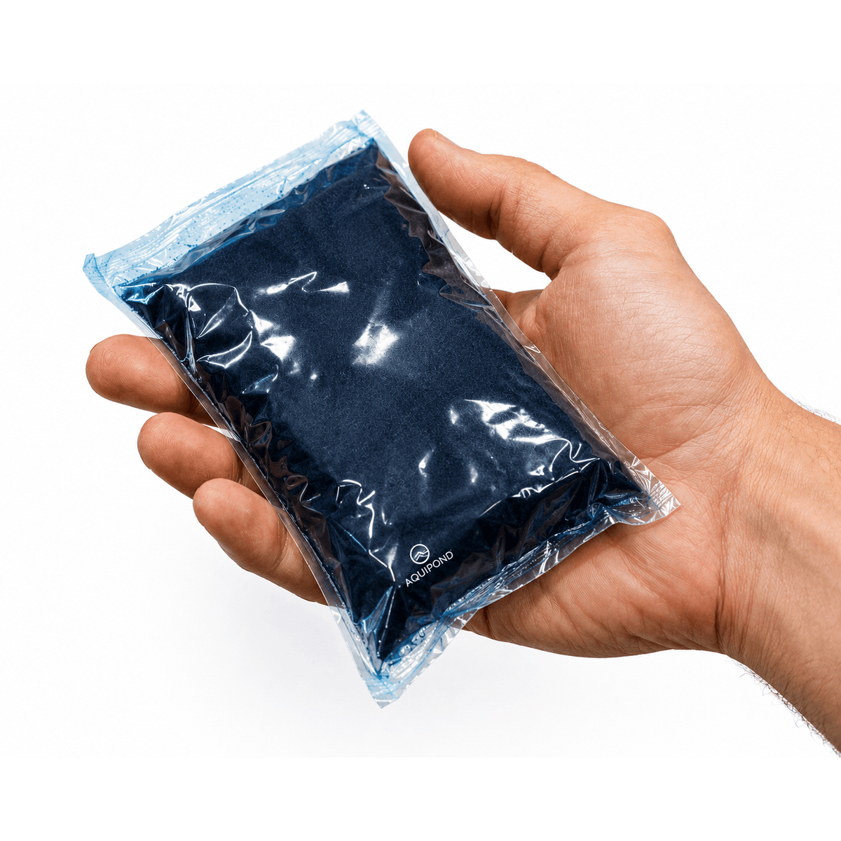 Sachet soluble de colorant bleu pour étang présenté dans une main